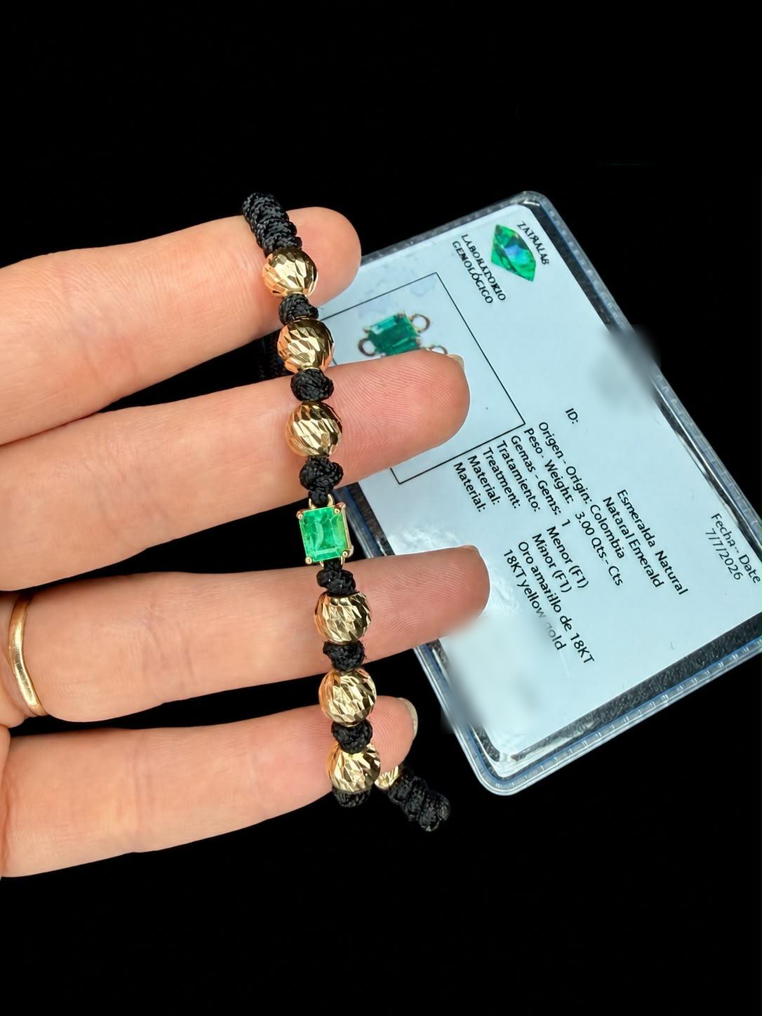 Manilla de caballero sostenida en la mano junto a su certificado gemológico